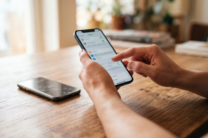 Pessoa configurando o celular novo ao lado do aparelho antigo para transferir o eSIM