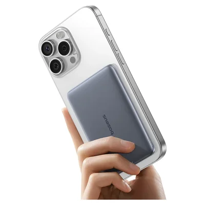 Mão segurando um iPhone com a bateria magnética Baseus PicoGo cinza presa atrás